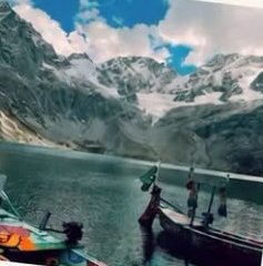 Boats on the turquoise Katora Lake below snowy peaks
